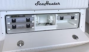 tackle box storage solution built into a boat for convenient storing of fishing gear while on the water