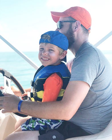 father and son driving a boat