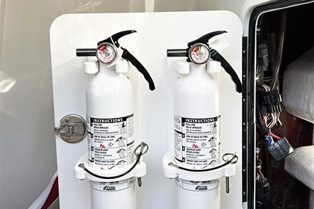 two fire extinguishers mounted on the back of a console door