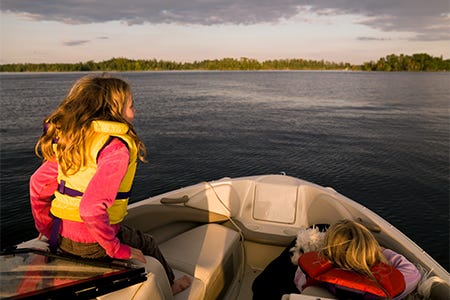 Kids enjoying a boat ride wearing their lifejackets