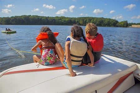 children wearing lifejackets while riding on a boat