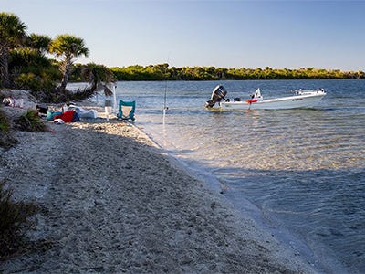 photo of a boat anchored on a sandbar close to a beach