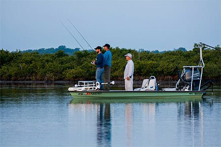 two guys on a flats boat fishing and learning with a charter captain