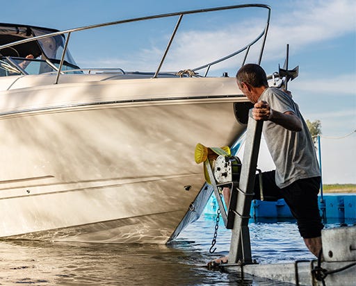 a man launching his boat off of the trialer at the boat ramp by himself