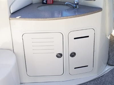 aluminum framed access doors with vented louvers installed to the side of a boat console below sink